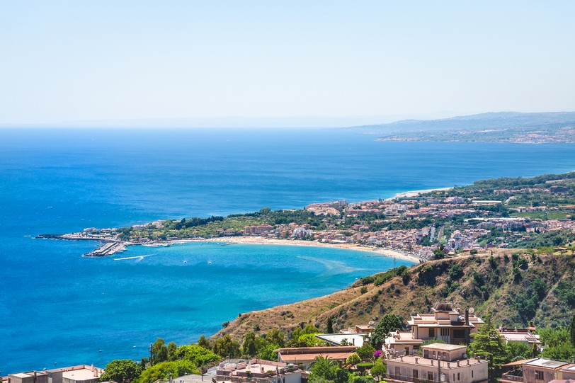 Taormina city and giardini naxos resort on the coast of Ionian sea from Castelmola village in Sicily shutterstock_604416593.jpg
